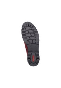Chaussure rouge avec une semelle en caoutchouc noir texturé dotée d'un motif de pédale multidirectionnel. Comprend un petit logo sur la semelle.