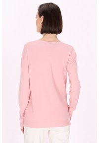 Suéter rosa claro hecho de tela suave, con mangas largas, un corte relajado y un escote redondeado. Diseño minimalista sin adornos.