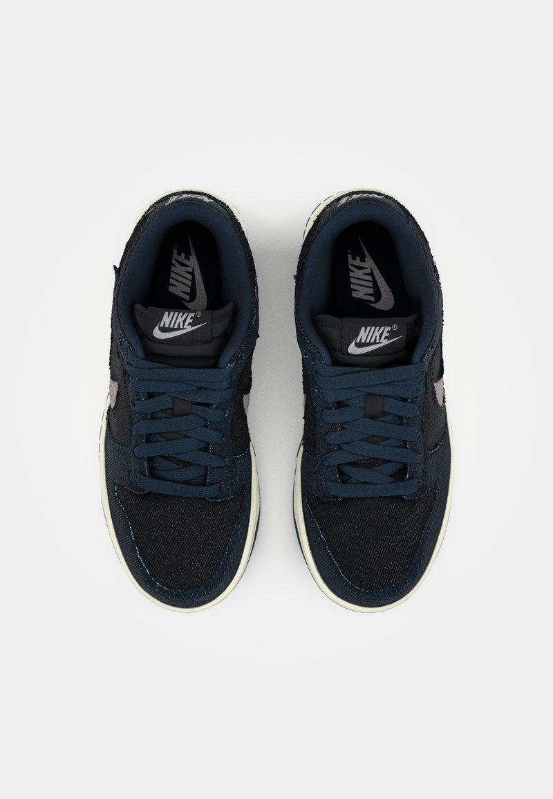 Baskets Nike bleu marine avec un dessus en denim texturé et en suède, bout rond et lacets plats. Présente une semelle intermédiaire blanche et des semelles intérieures noires.