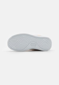 Hvit sneaker-såle med en lys blå gummibunn. Har sirkulære mønstre og en liten logo i midten.