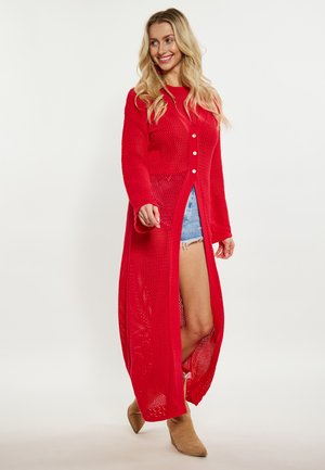 Red, knitted cardigan featuring a button closure and side slits. Designed with an open weave texture and long sleeves.