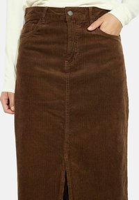 Brauer Cord-Ripprock mit vertikalen Streifen, Vorder-Schlitz, zwei seitlichen Taschen und einem Metallknopfverschluss an der Taille.