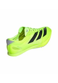 Zapatilla deportiva amarilla neón con rayas negras, parte superior de malla ligera y suela de goma. Presenta un acento gris en el talón y un diseño aerodinámico.