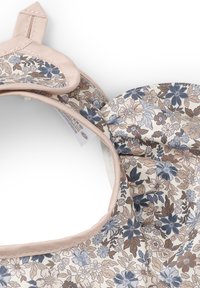 Blommönstrad solhatt med ett rosa tygband, prydd med nyanser av blå och bruna blommor på en ljus bakgrund. Mjuk, texturerad insida.