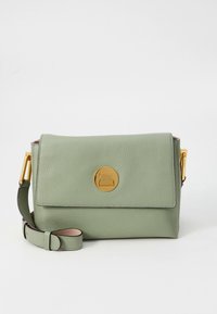 Grøn skuldertaske i læder med en guldcirkulær logo, klaplås og justerbar rem. Glat tekstur med en struktureret form.