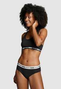 Schwarzes Sport-BH und Bikini-Set aus glattem Stoff, mit einem Logo-Band in Weiß, das eine enge Passform und Racerback-Design aufweist.