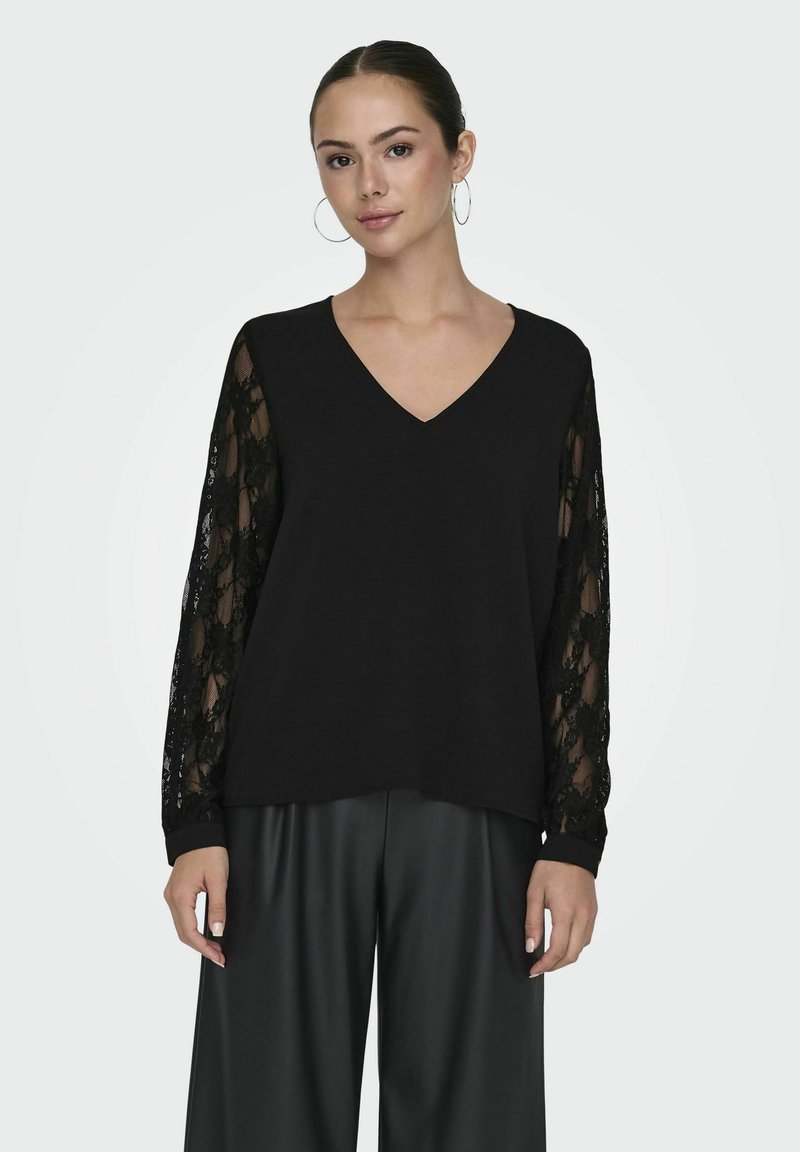 Czarna bluzka z dekoltem w serek i jednolitą sylwetką, mająca przezroczyste koronkowe długie rękawy. Materiał jest lekki, a projekt zawiera elastyczne mankiety.