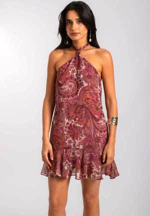 Vestido de cuello halter en color burdeos con patrón de paisley, tejido fluido y dobladillo con volantes. Cuenta con acentos metálicos en las muñecas.