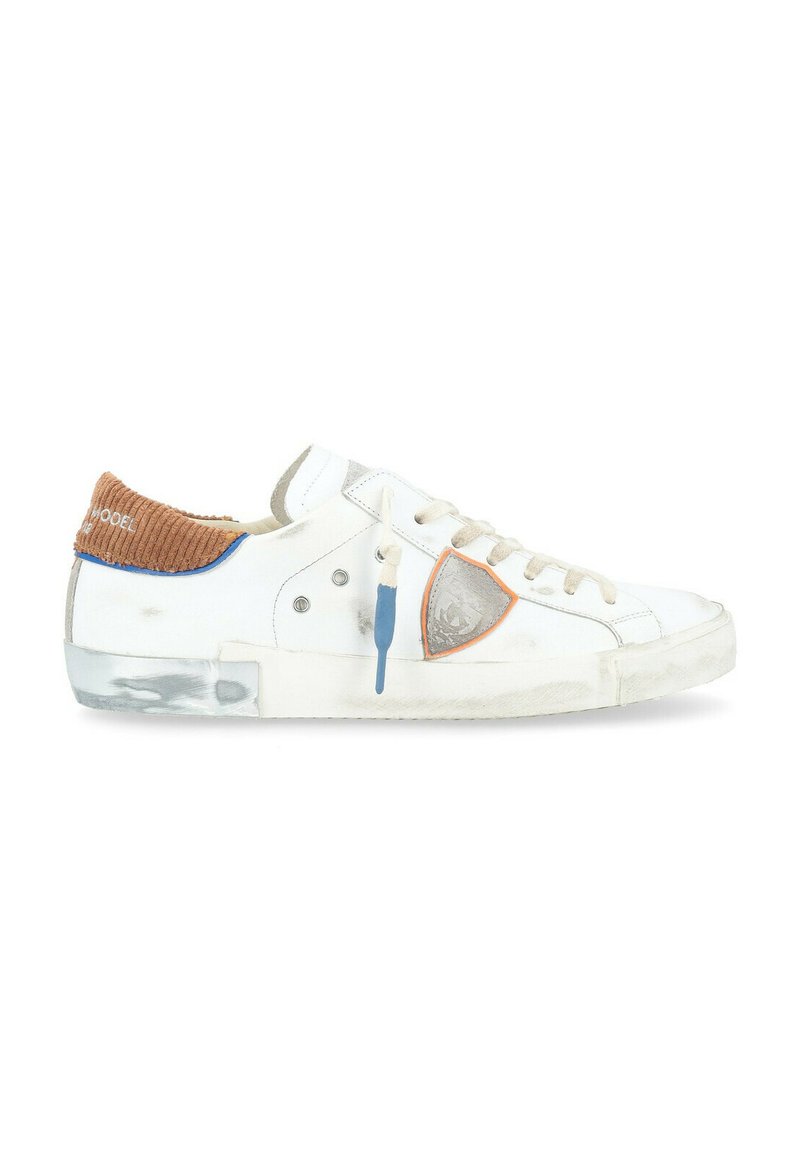 Sneaker bianco con colletto in corduroy beige, accenti blu e dettaglio del logo. Presenta lacci, suola in gomma e texture scalfita.