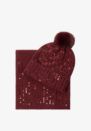 Cappello a maglia bordeaux con pom-pom e sciarpa abbinata, entrambi decorati con paillettes lucide in motivi verticali.