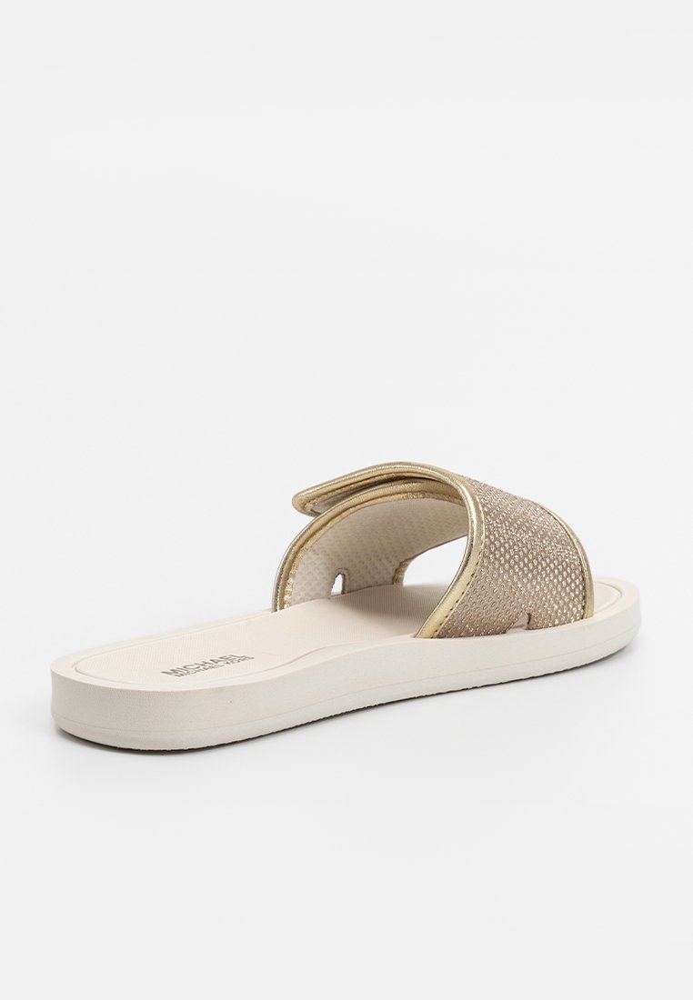 Sandale glissante beige avec une sangle texturée ornée de accents métalliques, semelle intérieure rembourrée et une semelle blanche élégante.