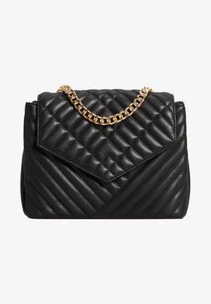 Zwarte gequilte leren handtas met een chevronpatroon, voorzien van een gouden kettingriem en een opgevouwen flapsluiting bovenaan.
