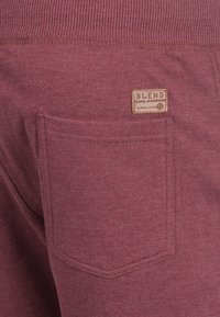 Bordo trenirke od mekog materijala s rebrastim pojasom, s jednom stražnjom džepom i smešnom oznakom od tkanine s natpisom "BLEND".