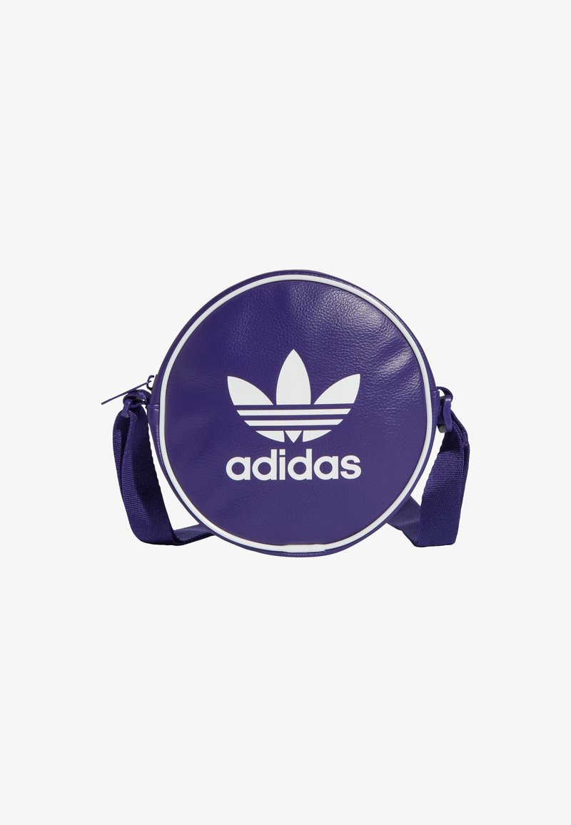 Runde lila Lederslingtasche mit weißem Adidas-Logo und Drei-Streifen-Emblem. Verstellbarer Stoff-Schultergurt. Glatte Textur.