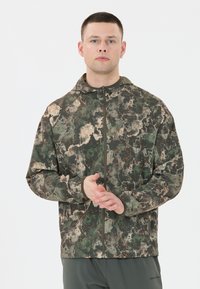 Kamik-mönstrad zip-up jacka i gröna, bruna och orange detaljer. Tillverkad av ett strukturerat tyg med en åtsittande huva och elastiska ärmslut.