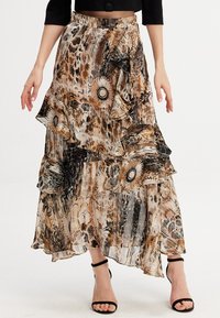 Jupe maxi fluide et à motifs en beige et noir, dotée de volants, de motifs floraux et d'un design superposé avec une texture transparente.