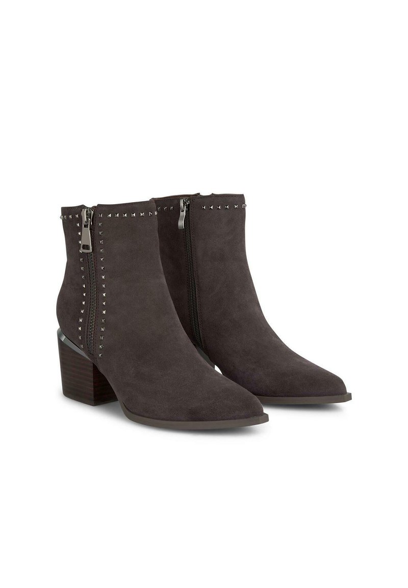 Botas de ante gris oscuro hasta el tobillo con punta afilada, cremalleras laterales y detalles de tachuelas a lo largo de las cremalleras. Los tacones en bloque adornan una base texturizada.