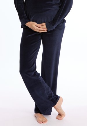 Pantalons de détente en velours bleu marine, avec une coupe décontractée, des jambes larges et une texture douce, associés à un haut à manches longues assorti.