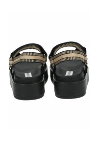 Sandali platform neri con cinturini intrecciati regolabili in beige e nero, dotati di una soletta liscia e texturizzata e di una suola robusta.