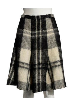 Jupe longueur genou avec large motif à carreaux noir et blanc, silhouette évasée et tissu en laine texturé sur un mannequin blanc.