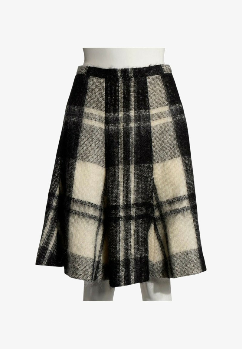 Jupe longueur genou avec large motif à carreaux noir et blanc, silhouette évasée et tissu en laine texturé sur un mannequin blanc.