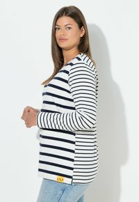 Langärmeliges T-Shirt mit horizontalen Marineblau- und weißen Streifen, aus Baumwolle. Enthält ein gelbes Logotag an der unteren Seite.