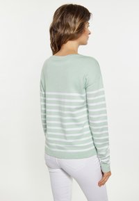 Maglione verde menta con righe bianche, maniche lunghe e scollatura a girocollo, realizzato in un tessuto morbido con una texture liscia.