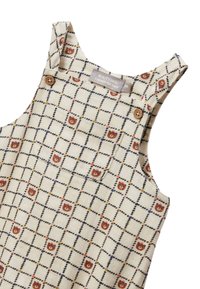 Grenouillère pour bébé en crème avec un motif à carreaux et de petites têtes d'ours en marron, boutons en bois sur les bretelles et une poche avant.