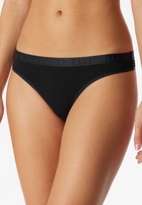 Czarne bikini wykonane z mieszanki bawełny z cienką, elastyczną talią, z subtelnym logo. Gładka faktura, minimalne zakrycie i klasyczny design.