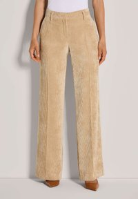 Beige Corduroyhosen mit geradem Bein, ausgestattet mit einer strukturierten Ripp-Oberfläche, seitlichen Taschen und einem taillierten Bund.