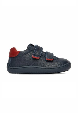 Dziecięcy granatowy skórzany sneaker z czerwonym akcentem na pięcie i dwoma regulowanymi paskami na rzep, prezentowany na białym tle.