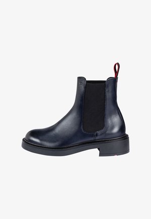 Bottine noire en cuir avec panneau latéral élastique, semelle épaisse et languette rouge à l'arrière.