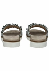 Šedé sandály s volánkovým páskem, měkkou podešví podobnou semiši a bílými texturovanými podrážkami. Minimalistický design a otevřená zadní část pro snadné obutí.