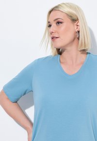 T-shirt azzurro chiaro a maniche corte con scollo a V, realizzato in tessuto morbido, caratterizzato da un design semplice e maniche dritte.