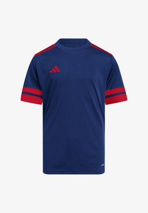 Granatowa koszulka sportowa z czerwonymi akcentami na rękawach i ramionach. Posiada okrągły dekolt i czerwony logo w postaci trzech ukośnych pasków na klatce piersiowej.