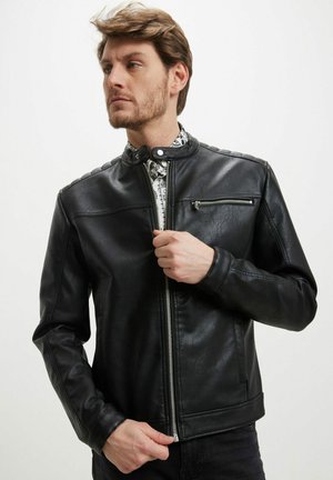 Veste en simili cuir noir avec un col haut, une fermeture éclair à l'avant et des accents sur les épaules. Comprend une poche à fermeture éclair sur le côté et une finition texturée.
