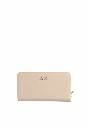 Cartera rectangular beige con cremallera alrededor y un sencillo logo metálico que presenta un triángulo y una X en el centro delantero.
