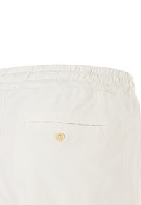 Béžové kraťasy s elastickým pasem a zadní kapsou s knoflíkovým zapínáním. Hladká bavlněná tkanina, minimalistický design a bez viditelných vzorů.