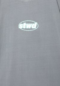Graues Baumwoll-T-Shirt mit einem hellblauen ovalen Logo, das den Text "stwd" in der Mitte zeigt. Klassischer Rundhalsausschnitt, weicher Stoff.