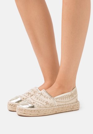 Bežové espadrilky s kovově stříbrnými špičkami, vyšívanými květinovými vzory, jutovými podešvemi a designem na obutí.