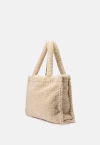Bolso tote de color beige, suave y acolchado, con una superficie texturada, forma rectangular y dos asas resistentes para un fácil transporte.