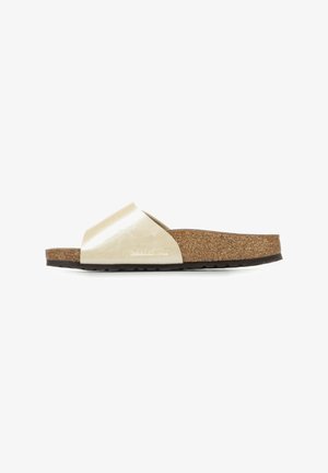 Metallic gold slide sandal with crossed straps, cork footbed, and rubber sole. Smooth texture on straps, detailed cork-like material on the sole.