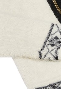 Tessuto a maglia bianco soffice con una texture pelosa, caratterizzato da un motivo geometrico nero e un accento di catena color oro lungo il bordo.