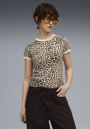Leopardprint t-shirt met een crèmekleurige kraag en manchetten, gemaakt van zachte stof, gecombineerd met donkere, loszittende broeken.