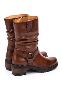Bottes de cheville en cuir marron avec un design décontracté, sangle texturée avec des éléments en métal argenté, bout rond et talon empilé avec rainures.