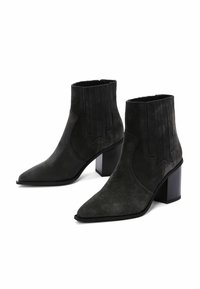 Black suede ankle boots with pointed toes, textured panels, and a chunky heel. Classic design with subtle detailing along the sides.