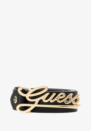 Črn umetni usnjeni pas z izstopajočo zlatometalno zaponko z logotipom "Guess", s gladko teksturo in enojno zatično zasnovo.