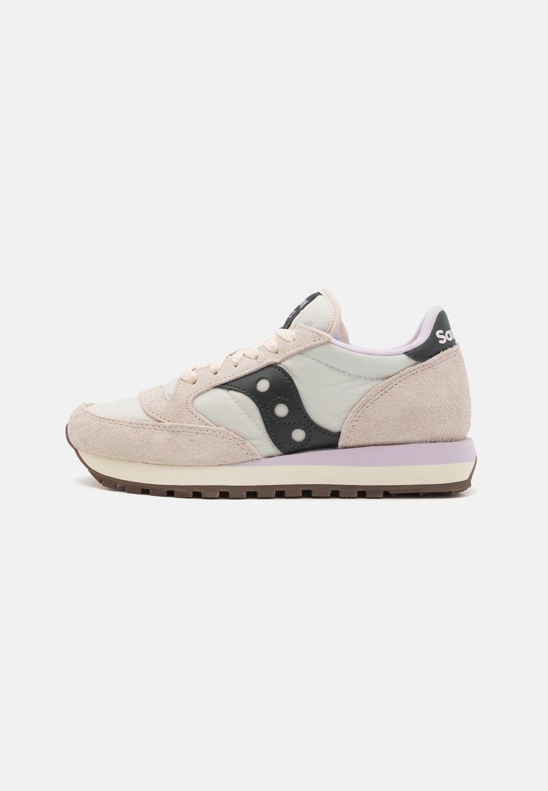 Baskets de sport beige et blanches avec un logo noir sur le côté, semelle intermédiaire violet clair et semelle en caoutchouc marron, vues de côté.