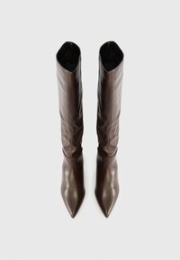 Smeđe kožne čizmice do koljena s oštrim vrhom i opuštenim gornjim dijelom, koje prikazuju glatku teksturu i suptilni sjaj.