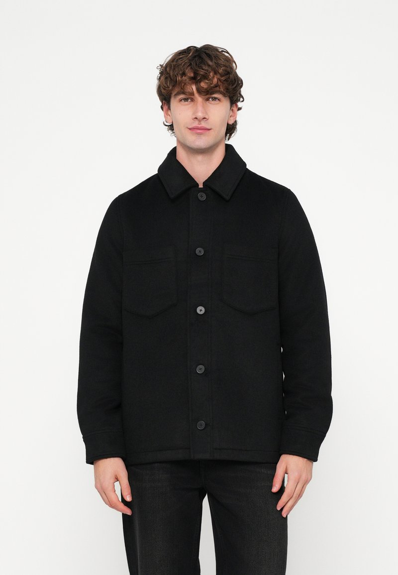 Sort uldblandet jakke med knaplukning foran, store påsyede lommer og en spids krave. Har en tekstureret finish og en afslappet pasform.
